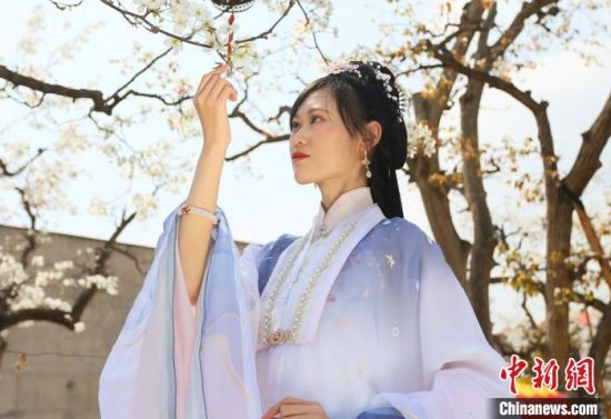 圖為蘭州青年身穿漢服在百年梨園賞景?！「哒?攝