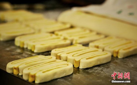 圖為面劑被涂上胡麻油，切成條狀用作月餅的花型制作。張文 攝