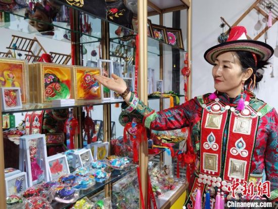 圖為身著民族服飾的隴原巧手展示手工藝品。(資料圖) 徐雪 攝