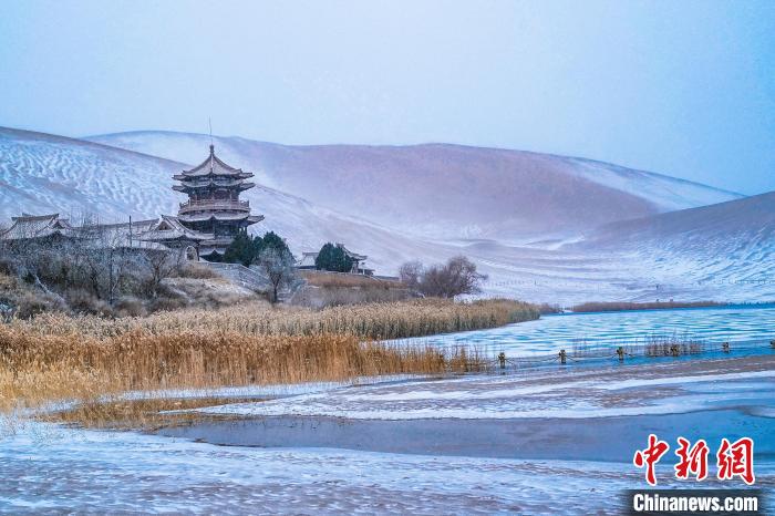 2021年11月28日，雪落鳴沙山月牙泉景區(qū)?！⊥醣筱y 攝