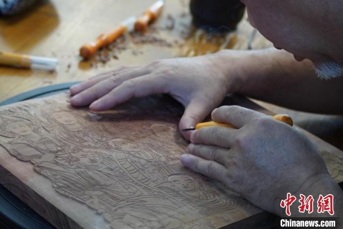 圖為徐晉林湊近木板，近距離制作雕版畫。　九美旦增 　攝