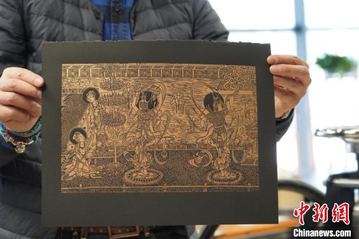 圖為手工書藝人展示敦煌雕版壁畫印刷品?！【琶赖┰?　攝