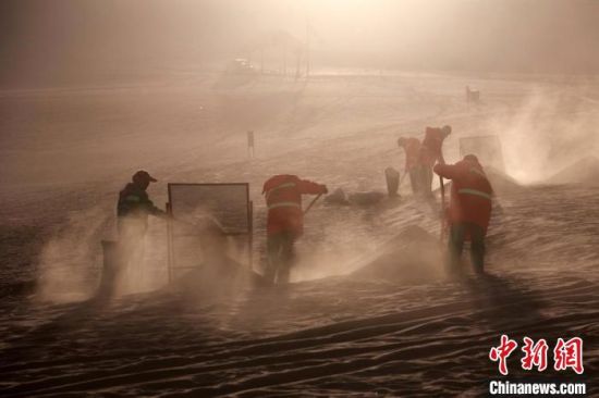 圖為敦煌市鳴沙山月牙泉景區(qū)“駱駝保姆”清理駱駝糞便?！垥粤?攝