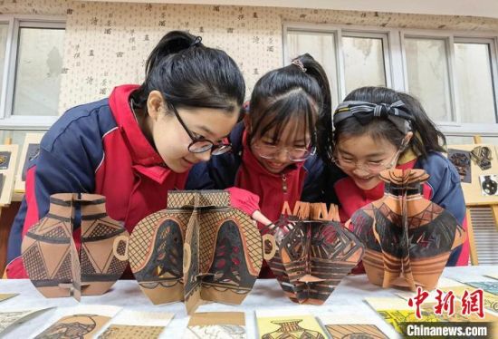 圖為學(xué)生用紙創(chuàng)作的立體彩陶?！⒂裉?攝