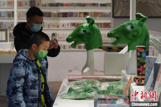圖為“神馬來了”銅奔馬頭套吸引參觀者駐足?！【琶赖┰?攝
