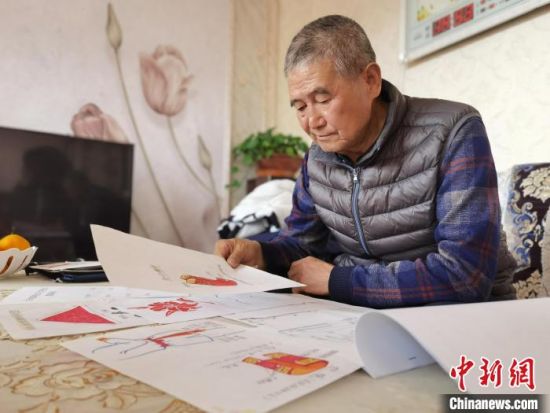 圖為陸鵬飛向記者展示多年帶隊(duì)的手寫筆記。　張婧 攝