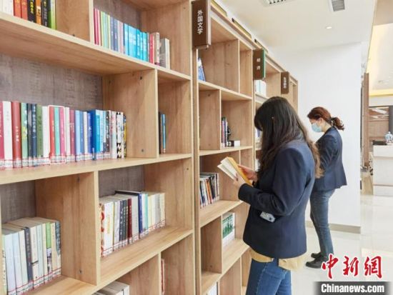 圖為在甘肅公航旅建設(shè)集團(tuán)有限公司的職工書屋，職工挑選書籍。　徐雪 攝