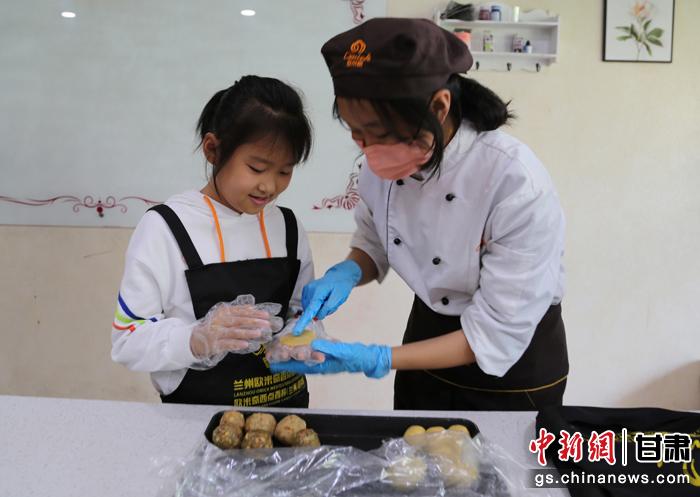 圖為在甘臺(tái)胞小朋友在工作人員指導(dǎo)下制作月餅。九美旦增 攝