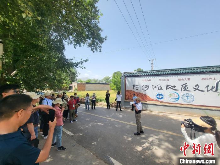 圖為中國地質(zhì)大學(xué)(北京)教授張緒教介紹村落情況?！『衍?攝