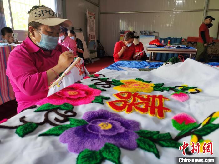 圖為婦女制作青繡?！?zhí)砀?攝