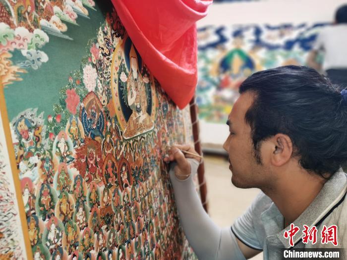 圖為更登才讓的徒弟繪畫唐卡。　張?zhí)砀?攝