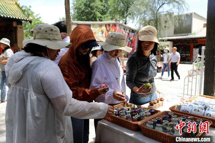 圖為民眾挑選手工藝產(chǎn)品?！⊙Φ?攝