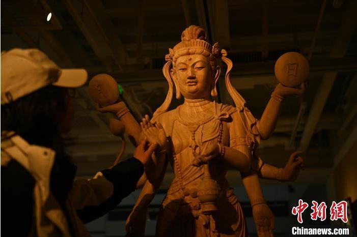 圖為季茂杰觀察自己創(chuàng)作的敦煌木雕。李亞龍 攝</p>
<p>