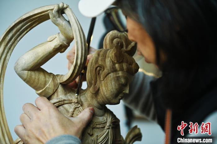 圖為季茂杰進(jìn)行敦煌元素的木雕創(chuàng)作。李亞龍 攝</p>
<p>