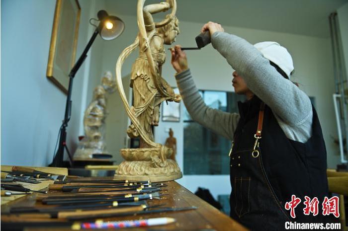 圖為季茂杰進(jìn)行敦煌元素的木雕創(chuàng)作。李亞龍 攝</p>
<p>