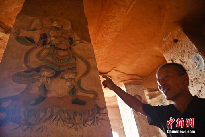 7月15日，甘肅省平?jīng)鍪袥艽h百里石窟長(zhǎng)廊羅漢洞石窟內(nèi)，該窟文保員郭建平介紹窟內(nèi)石刻彩繪壁畫。郭建平家中三代人曾自發(fā)保護(hù)羅漢洞石窟。羅漢洞石窟遺存40余個(gè)窟龕，以北魏至清代風(fēng)格為主。中新社記者 李亞龍 攝</p>
<p>