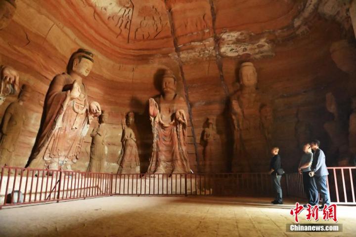 7月15日，游人參觀甘肅省平?jīng)鍪袥艽h百里石窟長(zhǎng)廊中的南石窟寺1號(hào)窟。百里石窟長(zhǎng)廊位于涇川縣境內(nèi)，由512個(gè)石窟、5眼窟中石井組成，現(xiàn)存王母宮石窟、鳳凰山石窟、南石窟寺、丈八寺石窟、羅漢洞石窟、太山寺石窟等規(guī)模較大的石窟群，還有數(shù)量眾多的小石窟群。南石窟寺開鑿于北魏永平三年，其中1號(hào)窟屬于大型七佛窟，七佛高達(dá)6米。中新社記者 李亞龍 攝