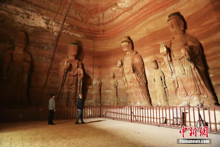 7月15日，游人參觀甘肅省平?jīng)鍪袥艽h百里石窟長(zhǎng)廊中的南石窟寺1號(hào)窟。百里石窟長(zhǎng)廊位于涇川縣境內(nèi)，由512個(gè)石窟、5眼窟中石井組成，現(xiàn)存王母宮石窟、鳳凰山石窟、南石窟寺、丈八寺石窟、羅漢洞石窟、太山寺石窟等規(guī)模較大的石窟群，還有數(shù)量眾多的小石窟群。南石窟寺開鑿于北魏永平三年，其中1號(hào)窟屬于大型七佛窟，七佛高達(dá)6米。中新社記者 李亞龍 攝