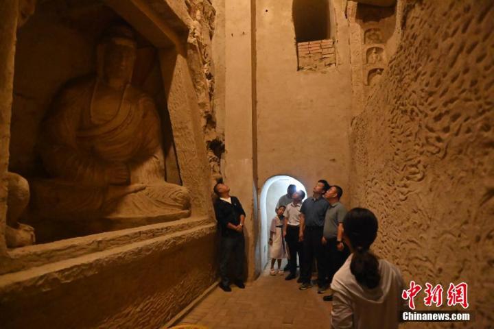 7月15日，游人參觀甘肅省平?jīng)鍪袥艽h百里石窟長(zhǎng)廊中的王母宮石窟。百里石窟長(zhǎng)廊位于涇川縣境內(nèi)，由512個(gè)石窟、5眼窟中石井組成，現(xiàn)存王母宮石窟、鳳凰山石窟、南石窟寺、丈八寺石窟、羅漢洞石窟、太山寺石窟等規(guī)模較大的石窟群，還有數(shù)量眾多的小石窟群。王母宮石窟又名千佛洞，該窟設(shè)計(jì)宏大，造像生動(dòng)，窟內(nèi)擁有造像數(shù)百尊，是較為珍貴的佛教文化歷史遺存。中新社記者 李亞龍 攝</p>
<p>