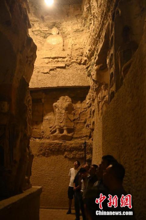 7月15日，游人參觀甘肅省平?jīng)鍪袥艽h百里石窟長(zhǎng)廊中的王母宮石窟。百里石窟長(zhǎng)廊位于涇川縣境內(nèi)，由512個(gè)石窟、5眼窟中石井組成，現(xiàn)存王母宮石窟、鳳凰山石窟、南石窟寺、丈八寺石窟、羅漢洞石窟、太山寺石窟等規(guī)模較大的石窟群，還有數(shù)量眾多的小石窟群。王母宮石窟又名千佛洞，該窟設(shè)計(jì)宏大，造像生動(dòng)，窟內(nèi)擁有造像數(shù)百尊，是較為珍貴的佛教文化遺存。中新社記者 李亞龍 攝</p>
<p>