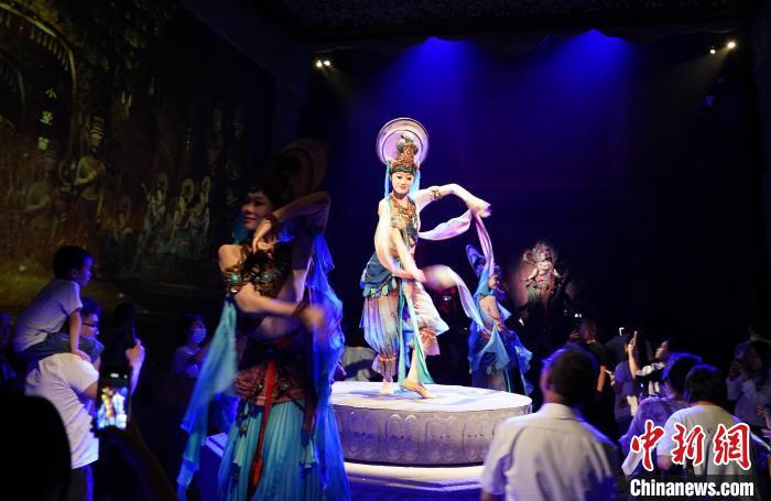 《樂(lè)動(dòng)敦煌》是全球首部洞窟式沉浸體驗(yàn)劇，利用真人與數(shù)字影像虛實(shí)交換實(shí)現(xiàn)沉浸式體驗(yàn)。圖為2023年8月28日晚，《樂(lè)動(dòng)敦煌》演出。(資料圖)中新社記者 毛建軍 攝