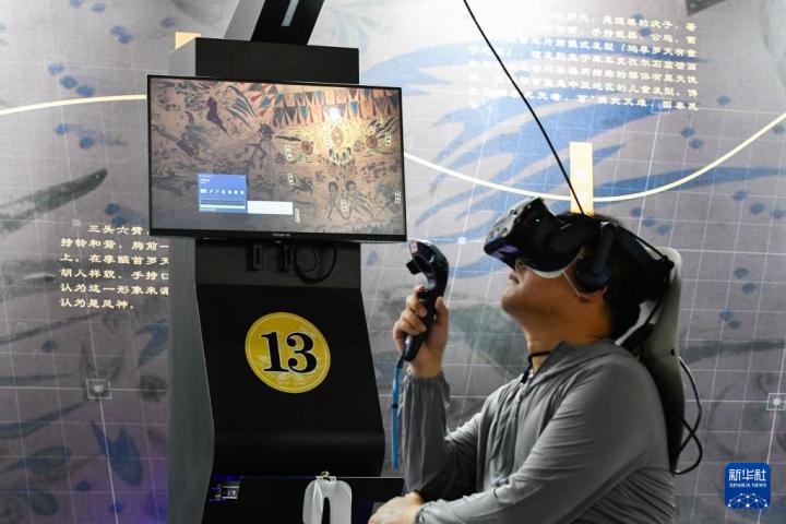 7月22日，游客借助VR設(shè)備沉浸式游覽莫高窟第285窟虛擬場景。新華社記者 郎兵兵 攝
